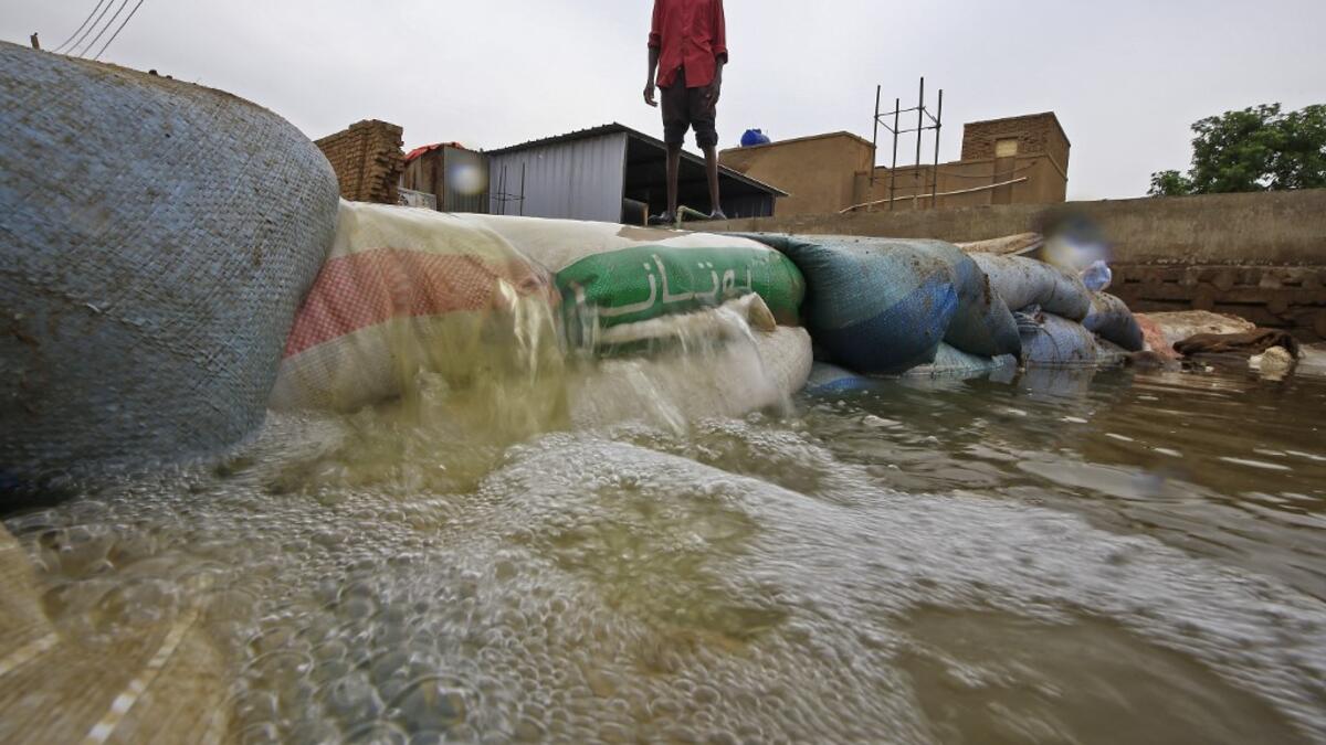 A Sudanese man stands behind a barricade amidst flood waters in Tuti island, where the Blue and White Nile merge between the twin cities of the capital Khartoum and Omdurman, on September 3, 2020. ASHRAF SHAZLY / AFP