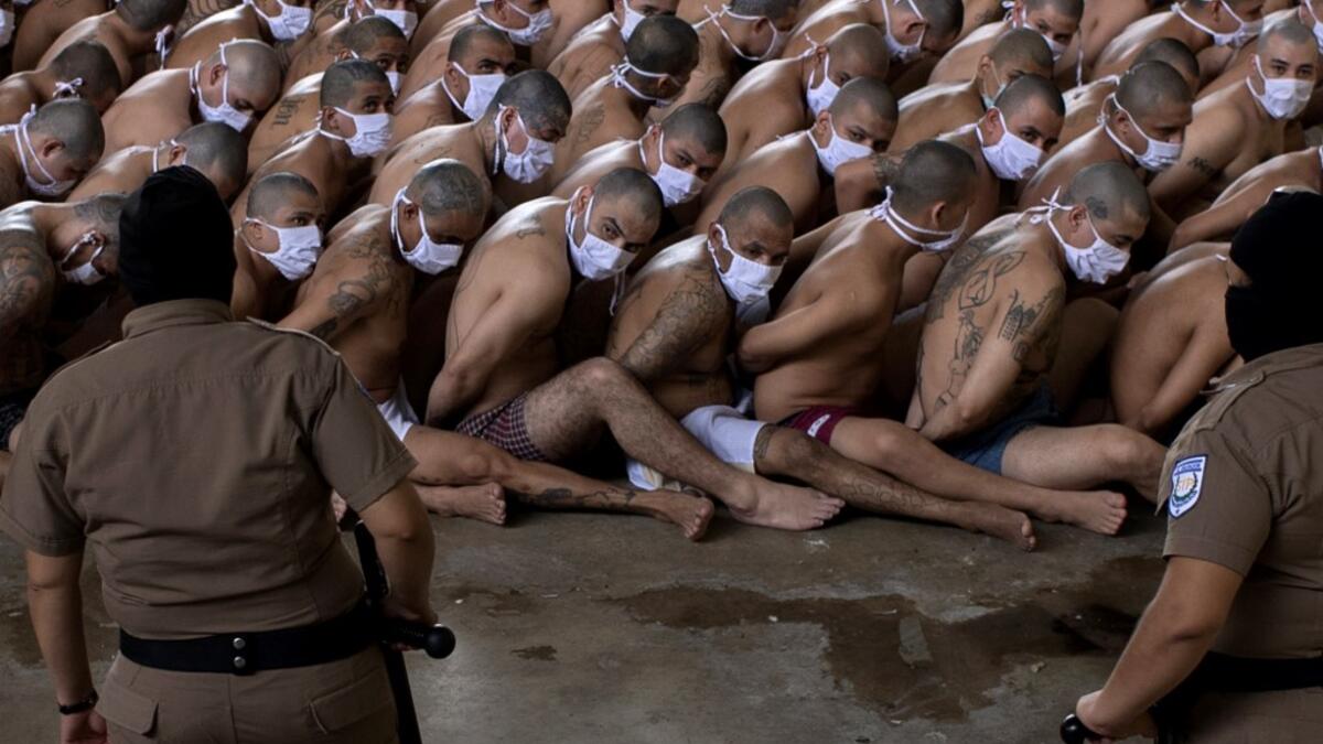 Members of the "Mara 18" and "MS-13" gangs are seen in custody of guards at a maximum security prison in Izalco, Sonsonate, El Salvador on September 4, 2020, amid the new coronavirus pandemic. The salvadoran government showed Friday the "strict" reclusion conditions of gang members in the country's prisons, amid a controversy generated by a journalistic report that denounced alleged benefits to imprisoned gang members to reduce homicides. Yuri CORTEZ / AFP