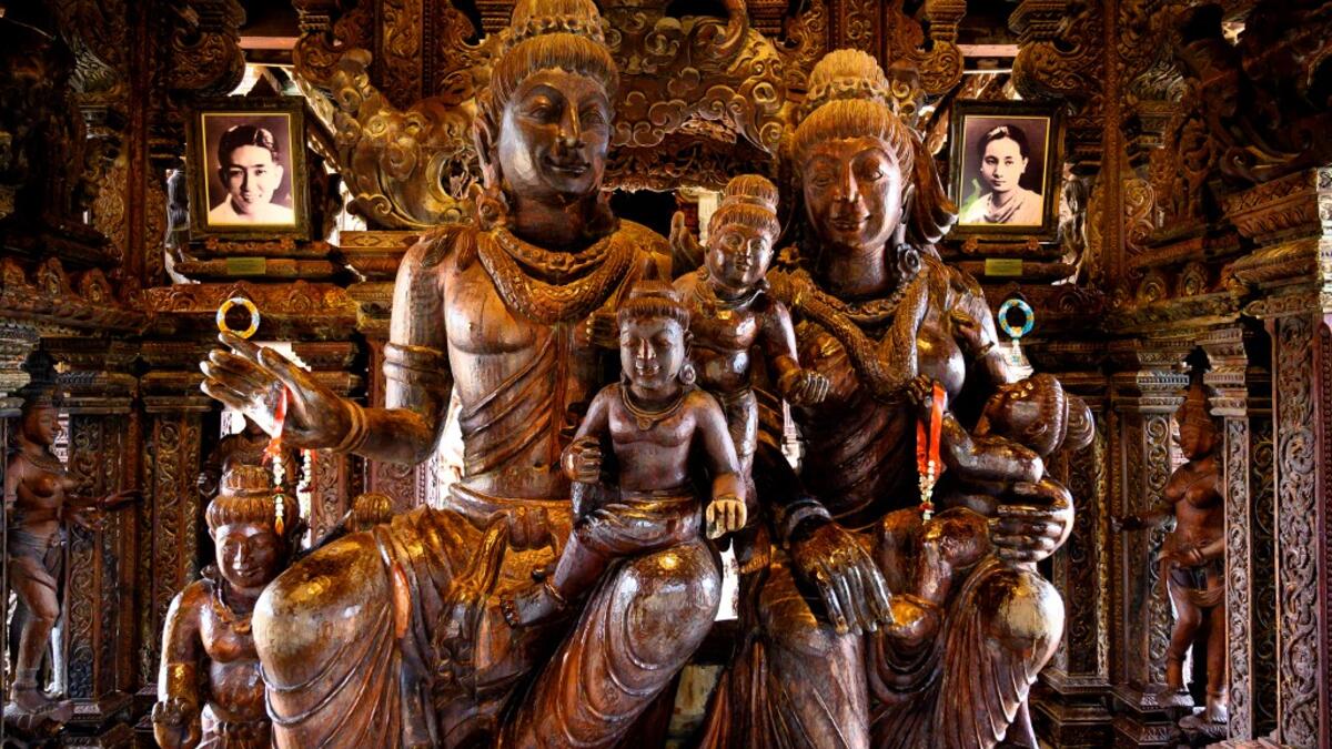 This photograph taken on September 1, 2020 shows the family statue with the portraits of the Thai businessman Lek Viriyaphan, who designed the temple, and his wife Prapai Viriyaphan in the all wooden Sanctuary of Truth Hindu-Buddhist temple and museum in Pattaya. Mladen ANTONOV / AFP