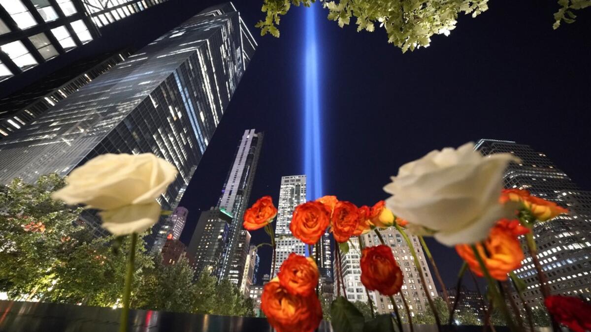 Roses are seen on the 9/11 Memorial as the Tribute in Light art installation shines into the sky over Manhattan on September 11, 2020 in New York to mark the 19th anniversary of the 9/11 attacks. TIMOTHY A. CLARY / AFP