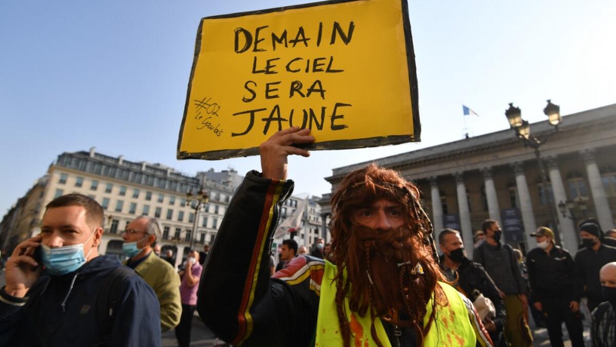 A man holds a placard reading "Tomorrow the sky will be yellow" as protesters wearing protectice face masks gather to take part in a demonstration called by the "yellow vest" (gilets jaunes) movement on September 12, 2020 in Paris. Alain JOCARD / AFP
