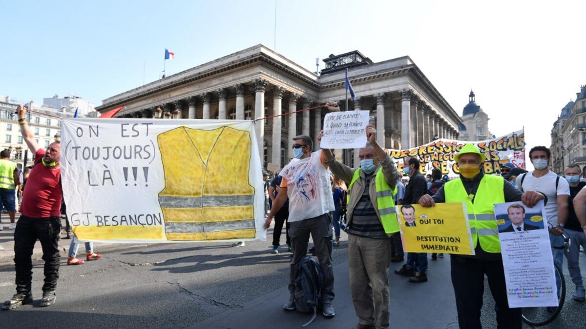 Protesters wearing protectice face masks holds placards and banners during a demonstration called by the "yellow vest" (gilets jaunes) movement on September 12, 2020 in Paris. Alain JOCARD / AFP