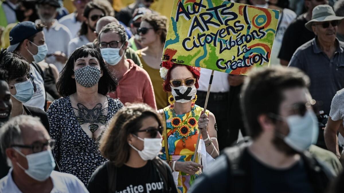 A protester wearing a face mask holds a sign reading "To arts citizen, free the creation" as they take part in a demonstration called by the "Yellow Vest" (Gilets Jaunes) movement in Bordeaux, southwestern France on September 12, 2020. Philippe LOPEZ / AFP