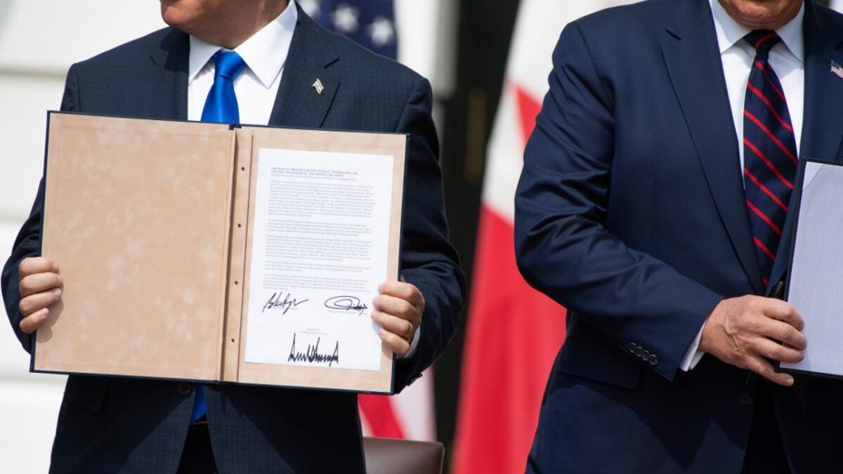 Israeli Prime Minister Benjamin Netanyahu(L) holds up the document after participating in the signing of the Abraham Accords where the countries of Bahrain and the United Arab Emirates recognize Israel, at the White House in Washington, DC, September 15, 2020. Israeli Prime Minister Benjamin Netanyahu and the foreign ministers of Bahrain and the United Arab Emirates arrived September 15, 2020 at the White House to sign historic accords normalizing ties between the Jewish and Arab states. SAUL LOEB / AFP