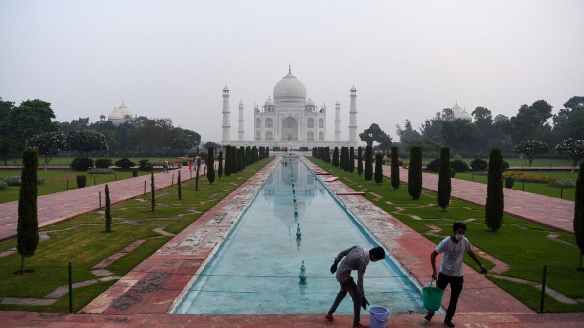 Workers clean the ground at the Taj Mahal in Agra on September 21, 2020. The Taj Mahal reopened to visitors on September 21 in a symbolic business-as-usual gesture even as India looks set to overtake the US as the global leader in coronavirus infections. Sajjad HUSSAIN / AFP