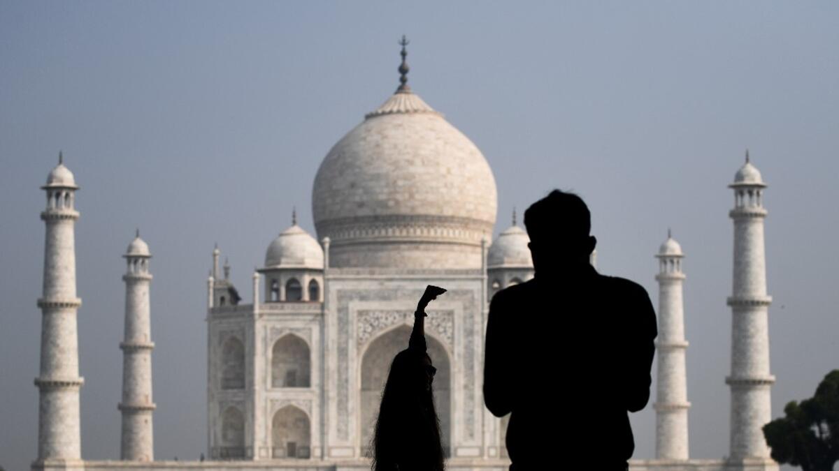 Tourists take pictures as the visit the Taj Mahal in Agra on September 21, 2020. The Taj Mahal reopened to visitors on September 21 in a symbolic business-as-usual gesture even as India looks set to overtake the US as the global leader in coronavirus infections. Sajjad HUSSAIN / AFP