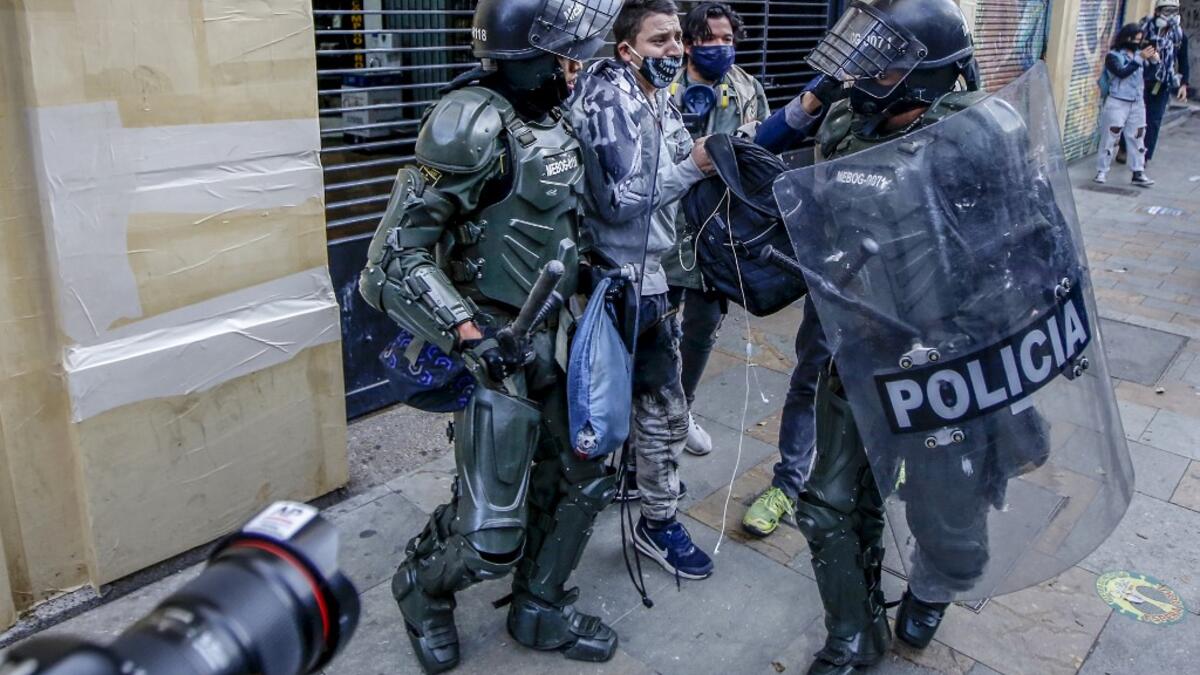 Riot police detain a demonstrator during protests against police brutality in Bogota on September 21, 2020. Large groups of protesters are mobilizing in Colombia against police violence and in rejection of the government, after the bloody protests that unleashed the recent murder of a man at the hands of two uniformed men. Leonardo MUNOZ / AFP