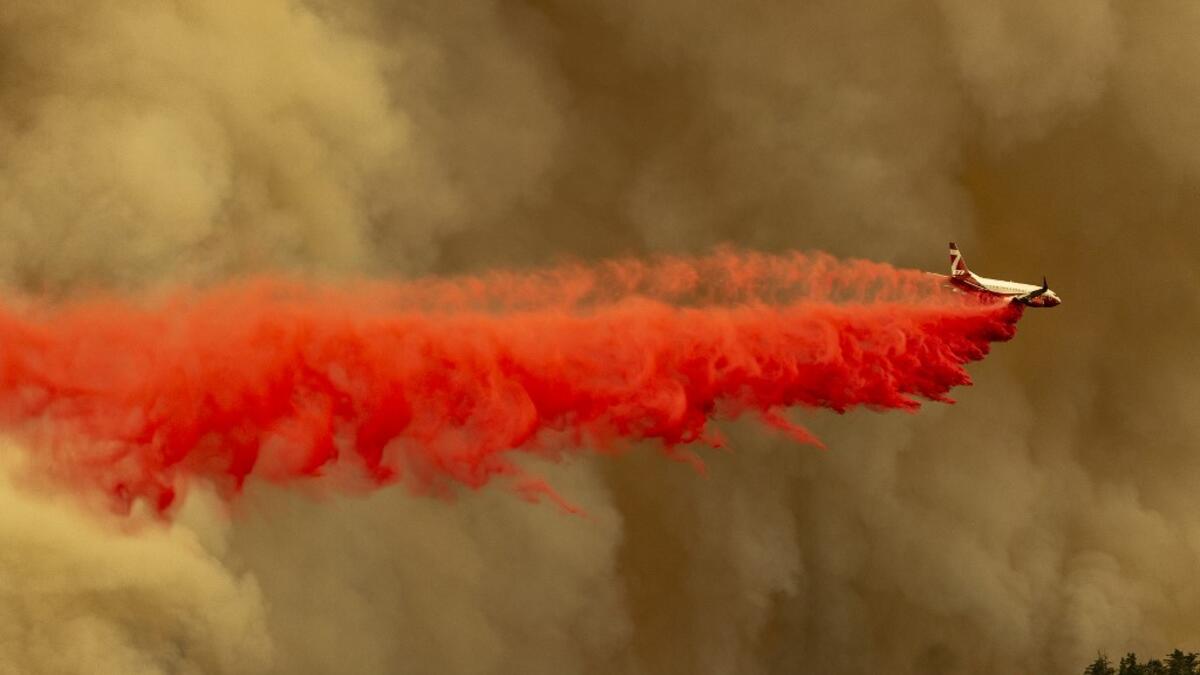 A Coulson 737 firefighting tanker jet drops fire retardant to slow Bobcat Fire at the top of a major run up a mountainside in the Angeles National Forest on September 10, 2020 north of Monrovia, California. California wildfires that have already incinerated a record 2.3 million acres this year and are expected to continue till December. The Bobcat Fire has grown to about 24,00 acres, and is 6% contained. David McNew/Getty Images/AFP DAVID MCNEW / GETTY IMAGES NORTH AMERICA / Getty Images via AFP