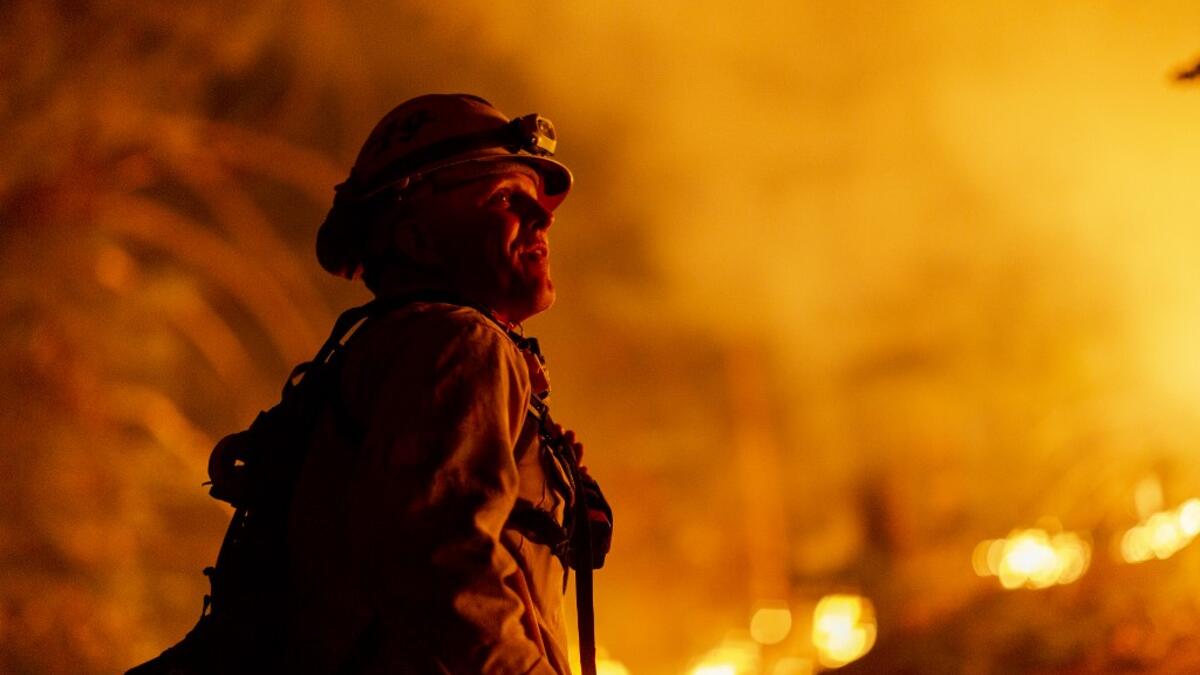 Los Angeles County firefighters, using only hand tools, keep fire from jumping a fire break at the Bobcat Fire in the Angeles National Forest on September 11, 2020 north of Monrovia, California. California wildfires that have already incinerated a record 2.3 million acres this year and are expected to continue till December. The Bobcat Fire has grown to more than 26,000 acres. David McNew/Getty Images/AFP DAVID MCNEW / GETTY IMAGES NORTH AMERICA / Getty Images via AFP