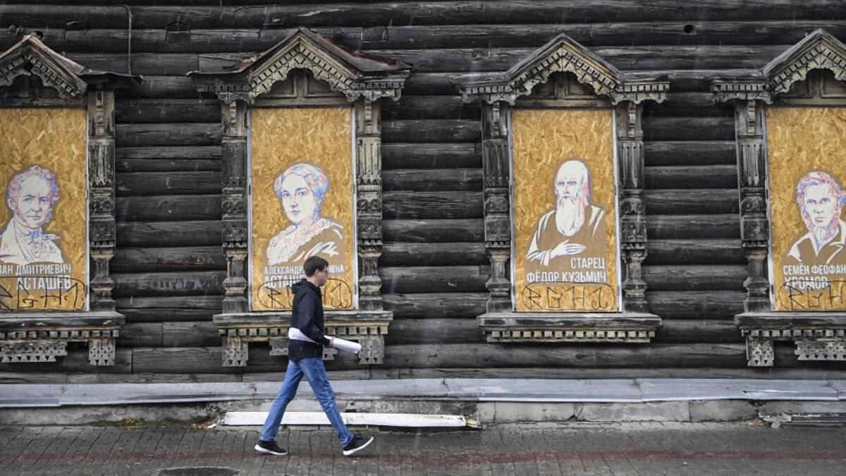 A man walks past a traditional wooden house in the Siberian city of Tomsk on September 8, 2020. Tomsk is considered to be one of the oldest towns in Siberia founded in 1604. Wooden architecture is one of the symbols of the city of Tomsk, its distinctive feature. Today Tomsk is the only city in Siberia where the background wooden buildings have been preserved, reflecting the manor structure of the city streets. Unfortunately, many wooden houses are not in very good condition and require restoration. Alexande