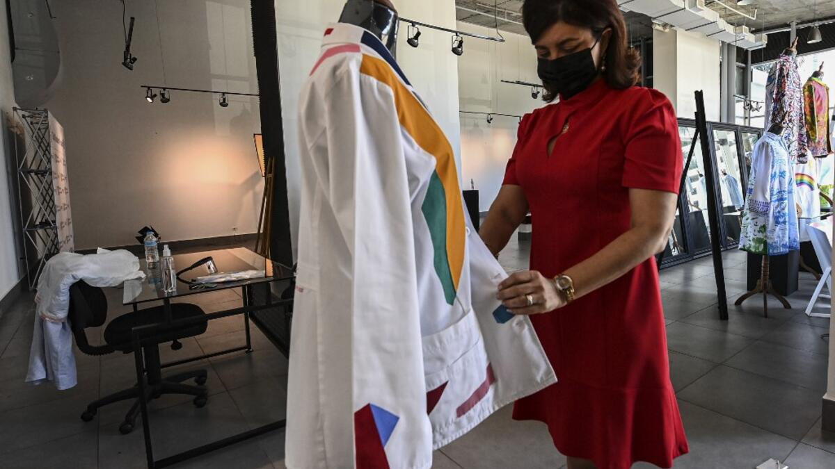 Dr. Fulvia Vergara holds her white coat decorated by Panamanian artist Genaro Rodriguez in Panama City, on September 26, 2020. More than 20 doctor's coats fighting against COVID-19 that were disinfected and painted by Panamanian artists will be auctioned off from October 1 to 4. The funds will go to 20 health centers. Luis ACOSTA / AFP