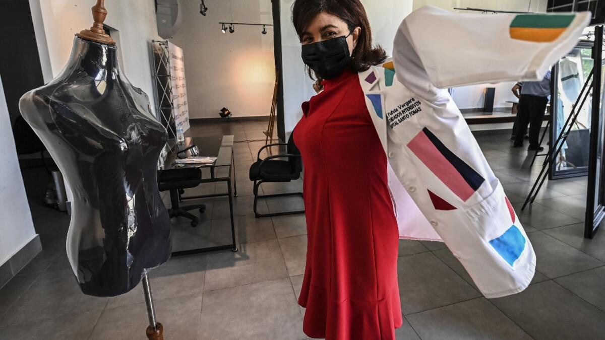 Dr. Fulvia Vergara wears her white coat decorated by Panamanian artist Genaro Rodriguez in Panama City, on September 26, 2020. More than 20 doctor's coats fighting against COVID-19 that were disinfected and painted by Panamanian artists will be auctioned off from October 1 to 4. The funds will go to 20 health centers. Luis ACOSTA / AFP