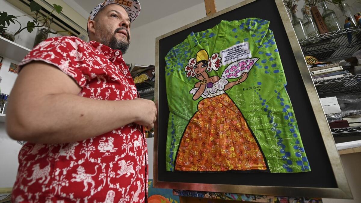 Panamanian artist Rolando de Sedas poses with the white coat used by Dr. Lilian Valdez and and decorated by him in Panama City, on September 25, 2020. More than 20 doctor's coats fighting against COVID-19 that were disinfected and painted by Panamanian artists will be auctioned off from October 1 to 4. The funds will go to 20 health centers. Luis ACOSTA / AFP