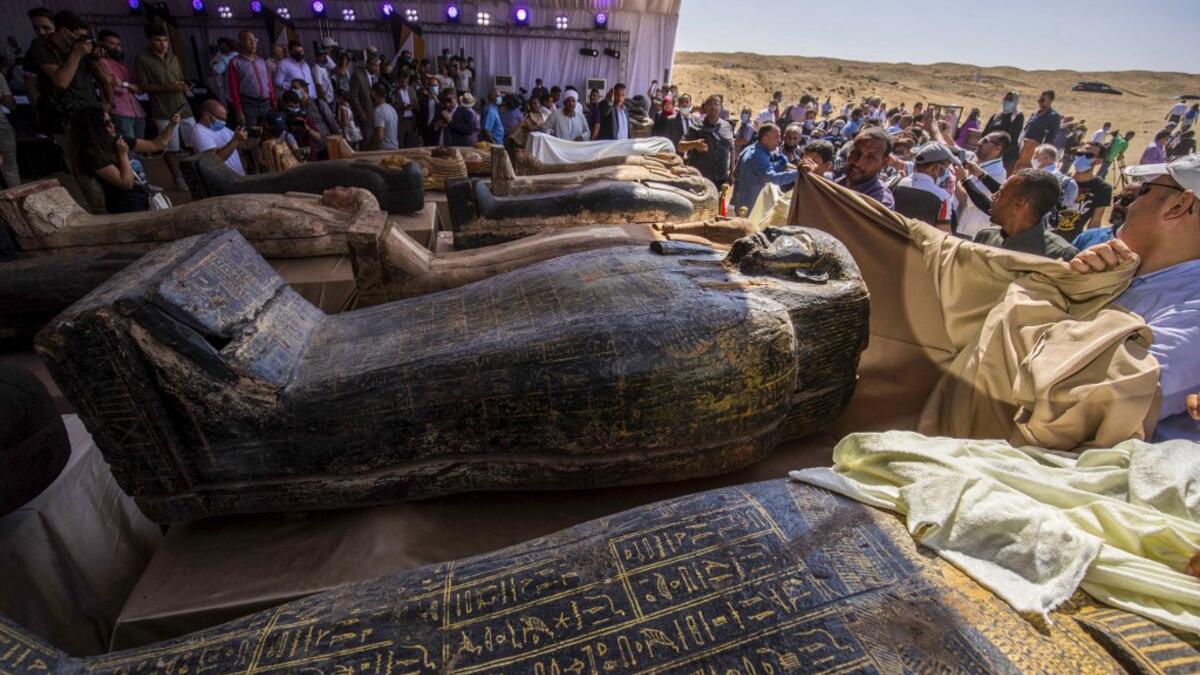 A picture taken on October 3, 2020 shows sarcophaguses, excavated by the Egyptian archaeological mission which discovered a deep burial well with more than 59 human coffins closed for more than 2,500 years, displayed during a press conference at the Saqqara necropolis, 30 kms south of the Egyptian capital Cairo. They were unearthed south of Cairo in the sprawling burial ground of Saqqara, the necropolis of the ancient Egyptian capital of Memphis, a UNESCO World Heritage site. Their exteriors are covered in