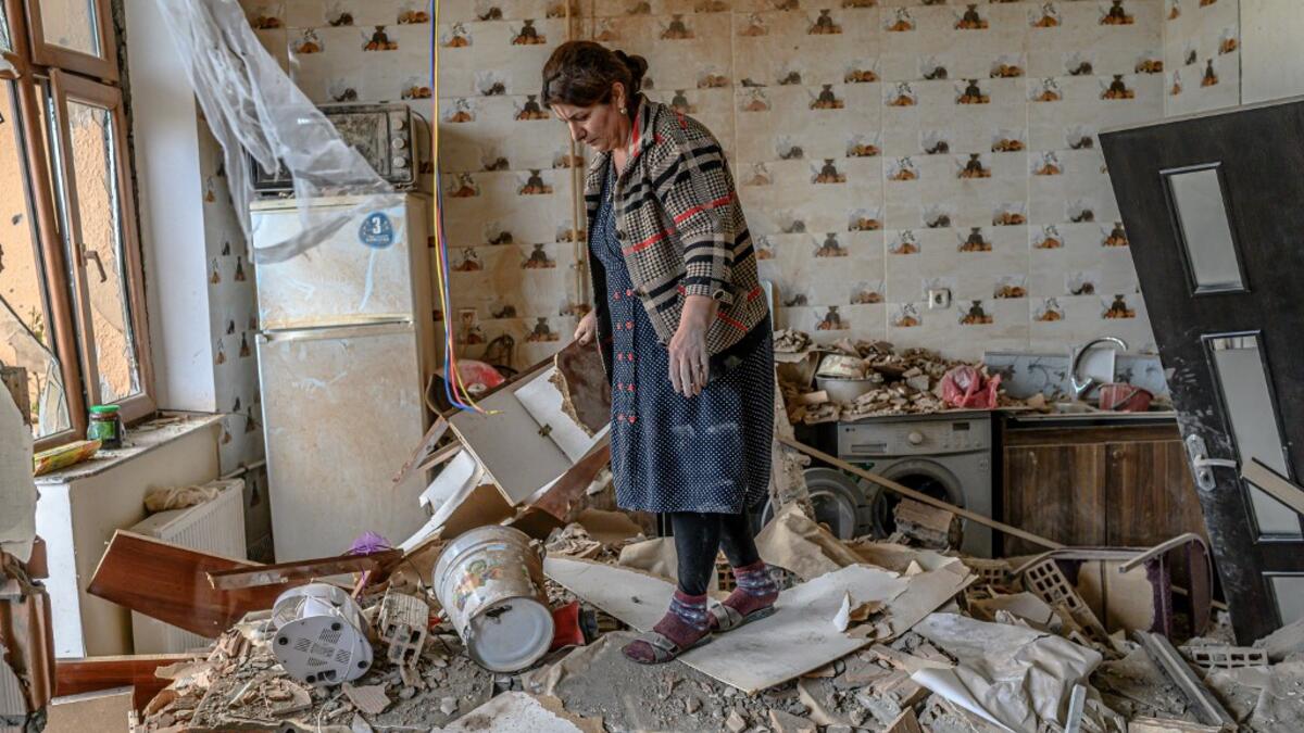 Xatire Celilova walks in the kitchen of her destroyed flat following a ceasefire during a military conflict between Armenia and Azerbaijan over the breakaway region of Nagorno-Karabakh, in the town of Terter, Azerbaijan, on October 10, 2020. Armenia and Azerbaijan traded accusations of new attacks on October 10 in breach of a ceasefire deal to end nearly two weeks of heavy fighting over the disputed Nagorno-Karabakh region. Bulent Kilic / AFP