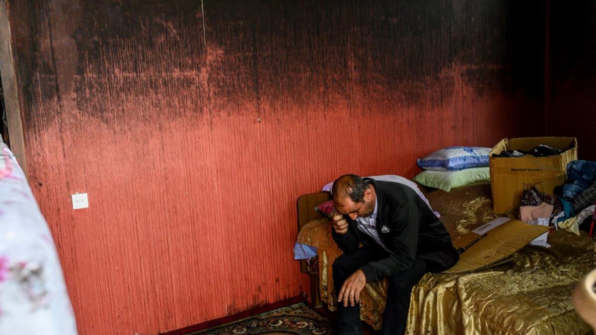 Razim Mehmedov, 40, sits in a bedroom of his flat that was damaged and burnt by shelling as residents return to their homes following a ceasefire during a military conflict between Armenia and Azerbaijan over the breakaway region of Nagorno-Karabakh, in the town of Terter, Azerbaijan, on October 10, 2020. Armenia and Azerbaijan traded accusations of new attacks on October 10 in breach of a ceasefire deal to end nearly two weeks of heavy fighting over the disputed Nagorno-Karabakh region. Bulent Kilic / AFP