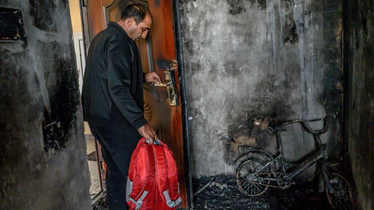 Razim Mehmedov, 40, holding his daughter's backpack stands in his flat that was damaged and burnt by shelling as residents return to their homes following a ceasefire during a military conflict between Armenia and Azerbaijan over the breakaway region of Nagorno-Karabakh, in the town of Terter, Azerbaijan, on October 10, 2020. Armenia and Azerbaijan traded accusations of new attacks on October 10 in breach of a ceasefire deal to end nearly two weeks of heavy fighting over the disputed Nagorno-Karabakh region