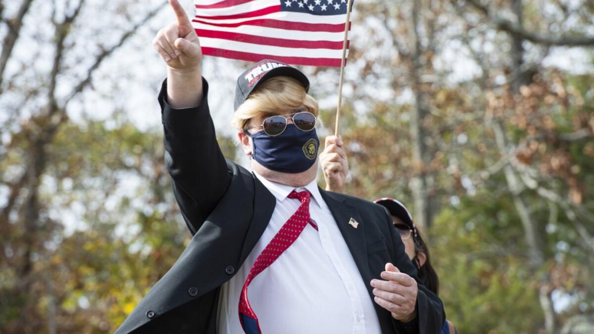 People dressed in political costumes participate in a contest during a Trump campaign rally named "Trumptoberfest" at Rocky Point Park in Warwick, Rhode Island on October 11, 2020. Many supporters dressed in political campaign clothing and waved flags while others dressed in festive costumes to take part in a political costume contest. Joseph Prezioso / AFP