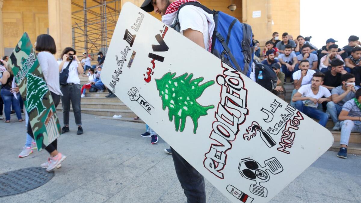 Lebanese demonstrators carrying shields attend a demonstration, marking the first anniversary of a non-sectarian protest movement, in the capital Beirut's downtown area on October 17, 2020. Anwar AMRO / AFP