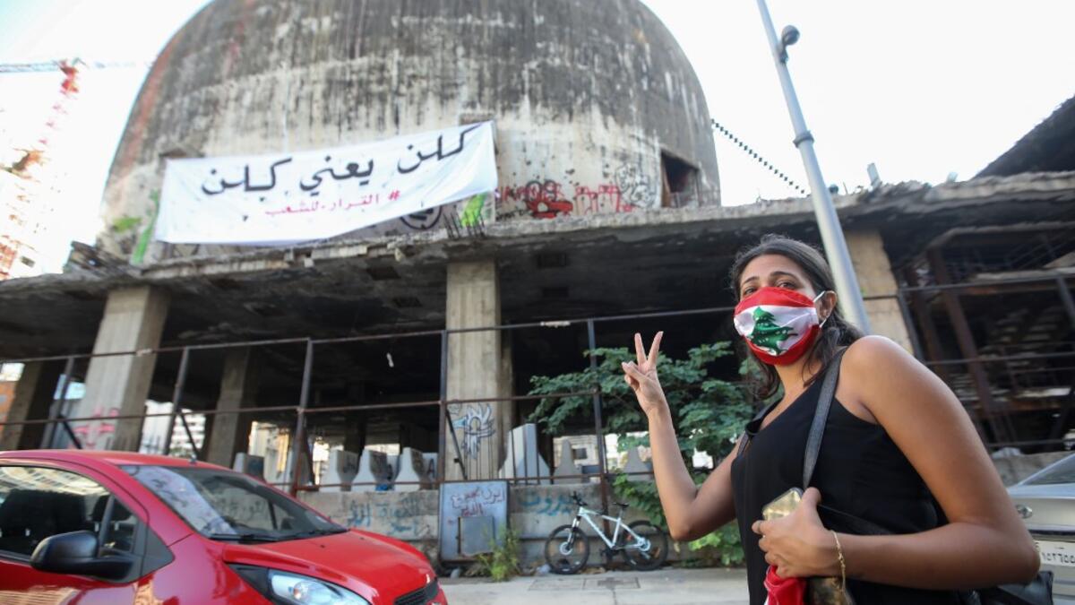 A Lebanese protester flashes the victory sign during a demonstration marking the one year anniversary of the beginning of a nationwide anti-government protest movement, in the capital Beirut on October 17, 2020. ANWAR AMRO / AFP