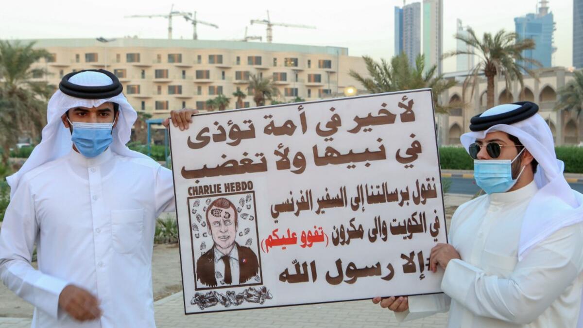 Kuwaitis lift placards expressing anger at French President Emmanuel Macron at a rally in front of the country's National Assembly (parliament) in Kuwait City, on October 24, 2020. Several Middle Eastern countries have slammed comments by President Emmanuel Macron defending cartoons of the Prophet Mohammed, with some instituting boycotts of French goods. AFP