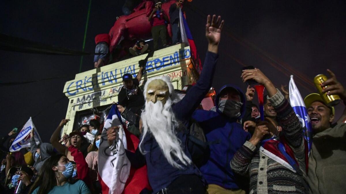 Demonstrators supporting the reform of the Chilean constitution celebrate while waiting for the referendum official results at Plaza Italia square in Santiago on October 25, 2020. Chile's President Sebastian Pinera called on the nation to work together for a "new constitution" after Chileans voted overwhelmingly to replace their dictatorship-era charter.  MARTIN BERNETTI / AFP