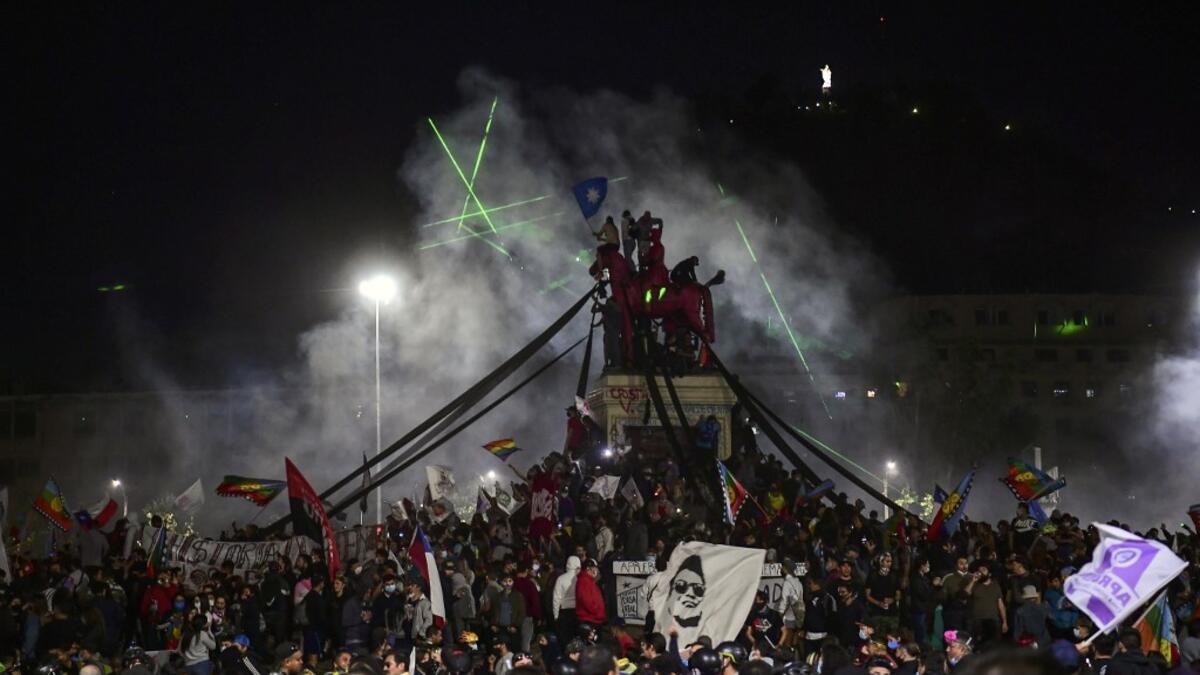 Demonstrators supporting the reform of the Chilean constitution celebrate while waiting for the referendum official results at Plaza Italia in Santiago on October 25, 2020. Chile's President Sebastian Pinera called on the nation to work together for a "new constitution" after Chileans voted overwhelmingly to replace their dictatorship-era charter. MARTIN BERNETTI / AFP