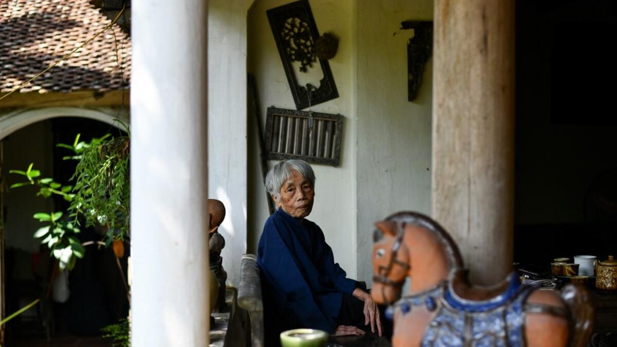 This photograph taken on October 8, 2020 shows 89-year-old Vietnamese artist Mong Bich posing at her house in Bac Ninh province, east of Hanoi. Bich specialises in silk paintings of daily life and ordinary people, women in particular, and ploughed a lonely furrow during many years of war when artists were steered towards the army or frontline workers as subjects. Manan VATSYAYANA / AFP