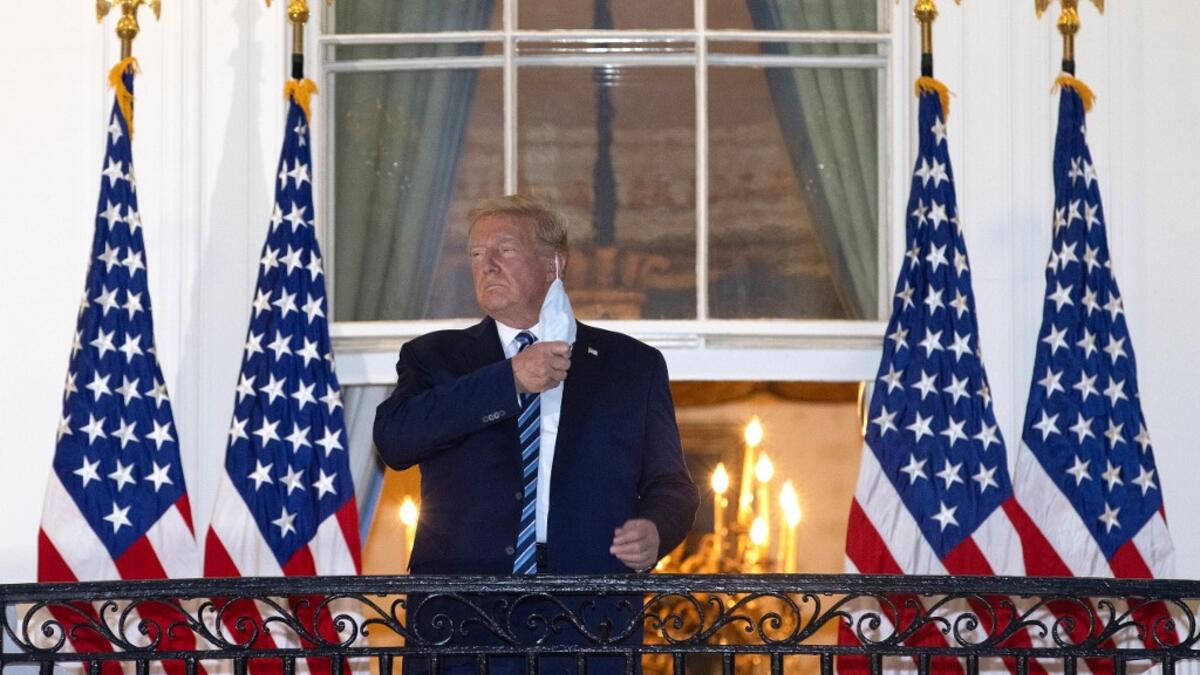President Donald Trump removes his mask upon return to the White House from Walter Reed National Military Medical Center on October 05, 2020 in Washington, DC. Trump spent three days hospitalized for coronavirus. Win McNamee/Getty Images/AFP WIN MCNAMEE / GETTY IMAGES NORTH AMERICA / Getty Images via AFP