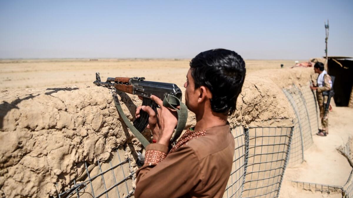 In this photo taken on September 27, 2020, a policeman keeps watch at an outpost set up against Taliban fighters at Aziz Abad village in Maiwand district of Kandahar province. The dry and dusty village of Aziz Abad in Maiwand district sits on the frontline of Afghanistan's war and is currently under government control -- but only just. WAKIL KOHSAR / AFP