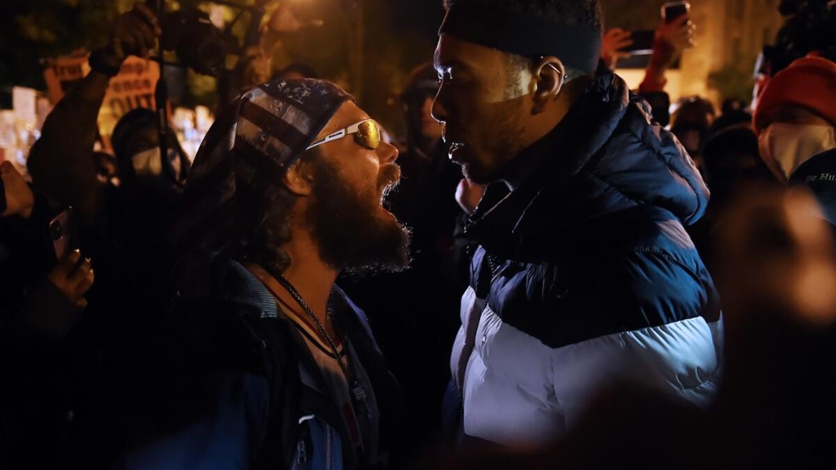 A US President Donald Trump supporter (L) clashes with a demonstrator at Black Lives Matter plaza across from the White House on election day in Washington, DC on November 3, 2020. Olivier DOULIERY / AFP