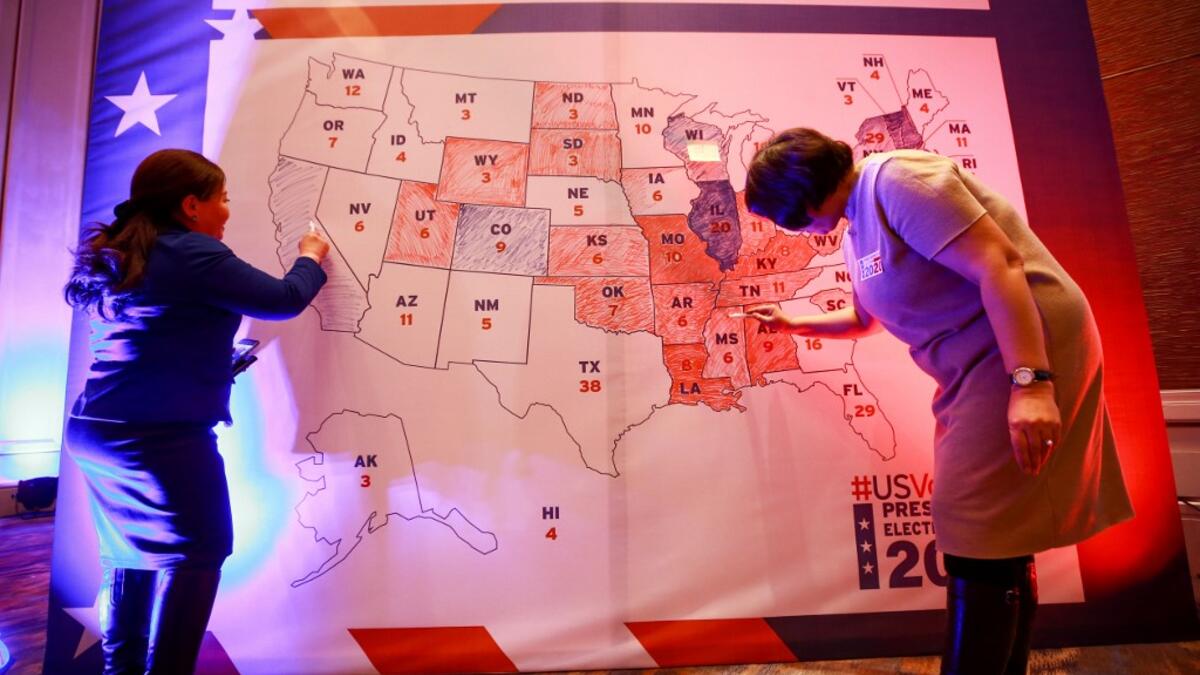 People colour in an electoral map during a US presidential election watch party at the US embassy in Ulaanbaatar, the capital of Mongolia on November 4, 2020. Byambasuren BYAMBA-OCHIR / AFP