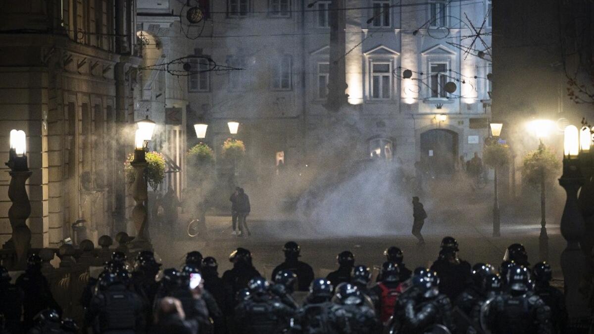 Protesters run through tear gas as they clash with police during the rally against government’s coronavirus restrictions in Ljubljana on November 5, 2020. Jure Makovec / AFP
