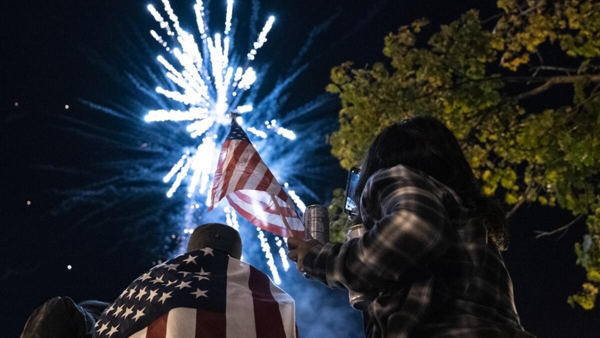 Supporters of US President-elect Joe Biden watch fireworks as they celebrate near the White House on November 7, 2020 in Washington, D.C. Democrat Joe Biden urged unity on November 7 and promised "a new day for America" in his first national address since he won the tense US election and ended the historically turbulent and divisive era of Donald Trump. Alex Edelman / AFP