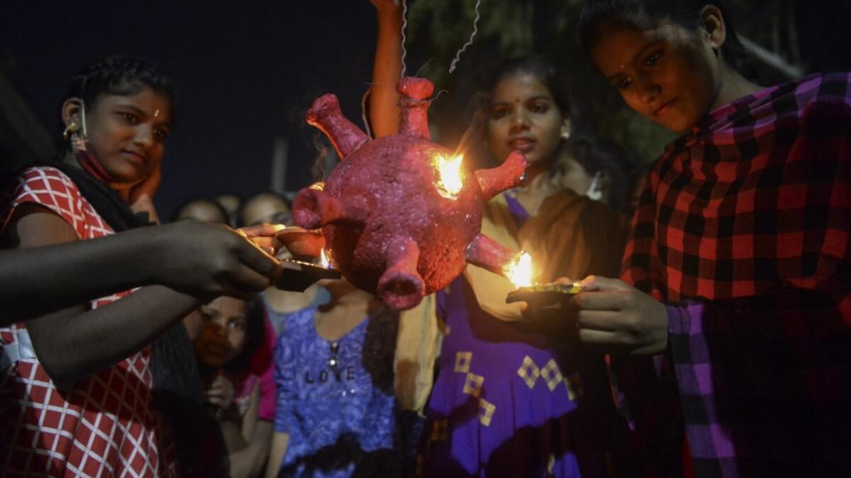 Students from a government girls hostel prepare to burn a Covid-19 coronavirus model during Diwali, the Hindu Festival of Lights, in Hyderabad on November 14, 2020. NOAH SEELAM / AFP