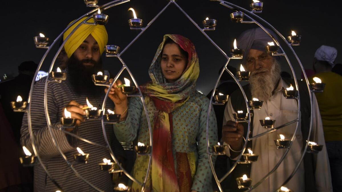 Sikh devotees light candles on the occasion of Bandi Chhor Divas, a Sikh festival coinciding with Diwali, the Hindu festival of Light, at the Golden Temple in Amritsar on November 14, 2020. NARINDER NANU / AFP