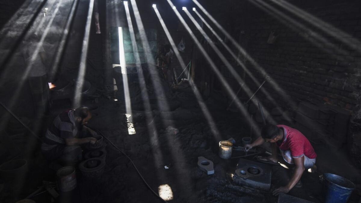 In this picture taken on November 16, 2020 dockyard workers prepare molds to make propeller at a workshop on the banks of the Buriganga river in Char Kaliganj on the outskirts of Dhaka. Rivers are the lifeblood of the delta nation of 168 million people where much of the low-lying land is accessed via boat, with Bangladesh's strong economic growth of recent years fuelling more investments in new and bigger ships. Munir UZ ZAMAN / AFP