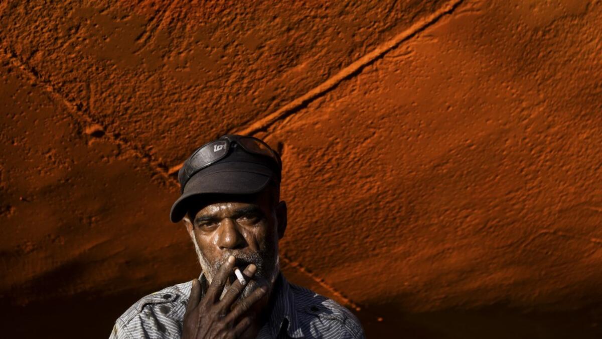 In this picture taken on November 11, 2020 dockyard worker smokes a cigarette next the hull of a ship on the banks of the Buriganga river in Char Kaliganj on the outskirts of Dhaka. Rivers are the lifeblood of the delta nation of 168 million people where much of the low-lying land is accessed via boat, with Bangladesh's strong economic growth of recent years fuelling more investments in new and bigger ships. Munir UZ ZAMAN / AFP