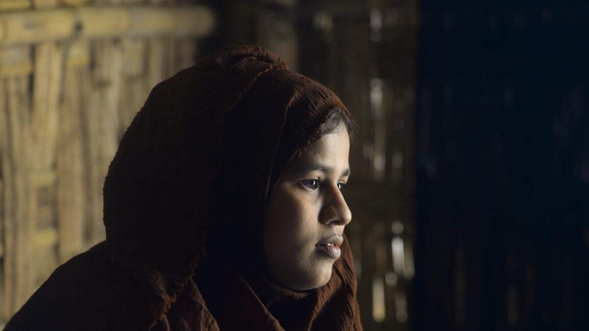 In this photograph taken on October 13, 2020, Rohingya refugee Umme Khair, who gave money to a community leader to travel to Malaysia to her husband, sits at a makeshift shelter in Kutupalong Rohingya refugee in Ukhia. Stay in a squalid refugee camp -- hopeless, starving, and made to feel a burden -- or leave, risking death, rape, human trafficking and months at sea to reach a husband you've never met. This is the bleak choice many Rohingya women, already scarred from fleeing persecution in Myanmar, are now