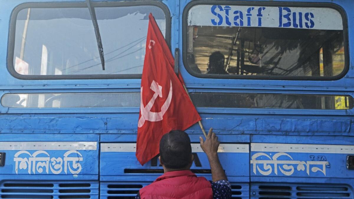 An activist of Communist Party of India (Marxist) (CPI-M) stops a bus as he blocks a road during a rally to support nationwide general strike called by farmers to protest against the recent agricultural reforms in Siliguri on December 8, 2020. Diptendu DUTTA / AFP