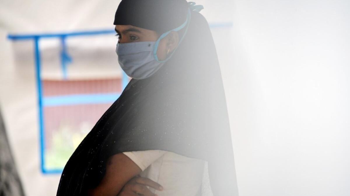 This photo taken on October 21, 2020 shows Rohingya refugee Janu, 18, whose family had arranged to marry a Rohingya man working as a labourer in Malaysia, at a temporary shelter in Lhokseumawe, Indonesia's Aceh province. Stay in a squalid refugee camp -- hopeless, starving, and made to feel a burden -- or leave, risking death, rape, human trafficking and months at sea to reach a husband you've never met. This is the bleak choice many Rohingya women, already scarred from fleeing persecution in Myanmar, are n