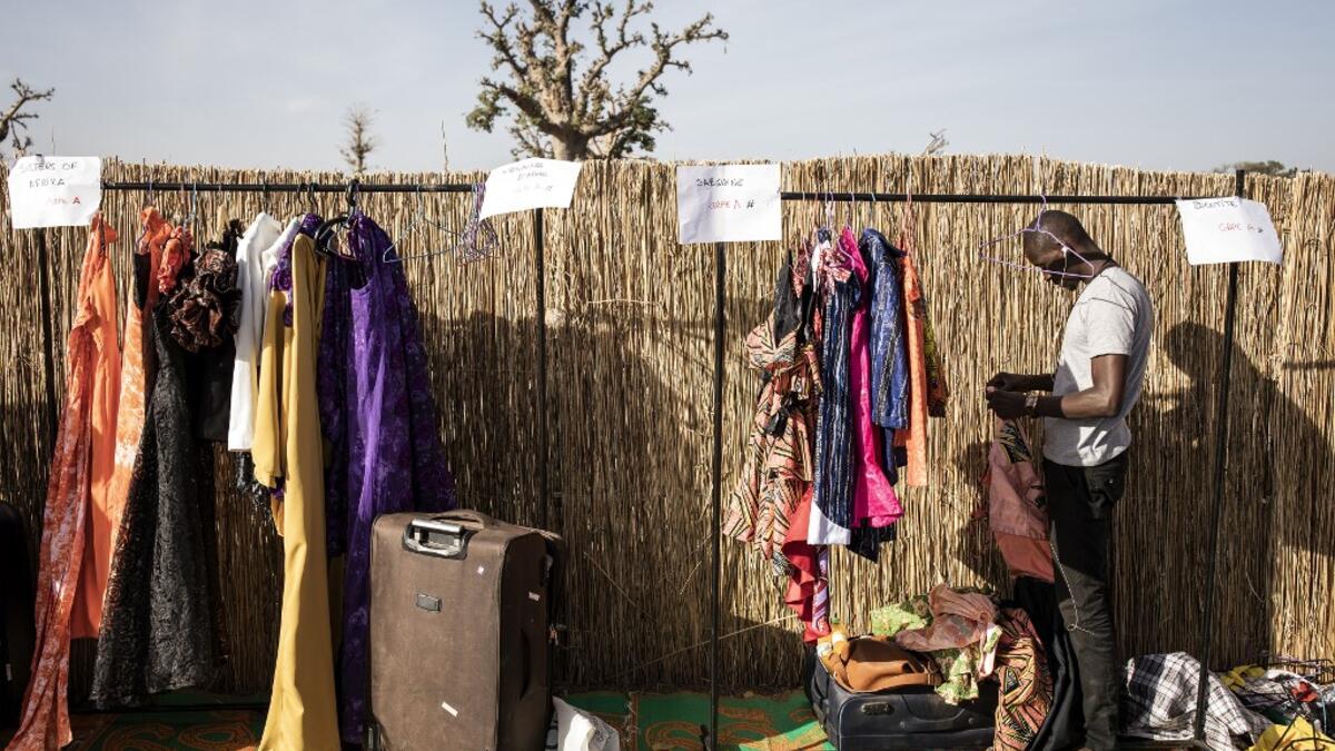 A designer unpacks his collection ahead of the start of Dakar Fashion Week in Dakar on December 12, 2020. JOHN WESSELS / AFP