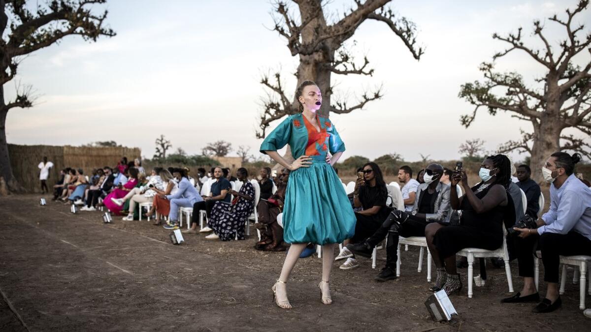 A fashion model poses at the end of the runway during Dakar Fashion Week in Dakar on December 12, 2020. JOHN WESSELS / AFP