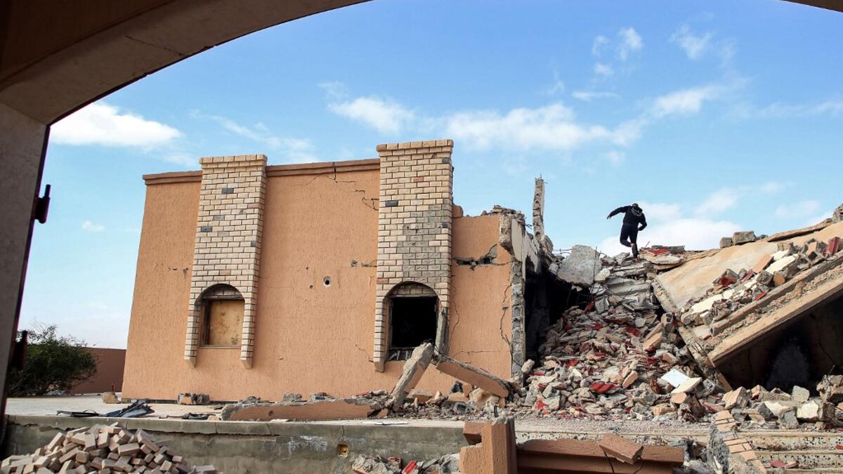 A youth climbs the rubble of a destroyed building in the city of Tawergha, some 200 kilometres (125 miles) east of Libya's capital close to the port city of Misrata, on December 12, 2020. When Libyan dictator Moamer Kadhafi was toppled, people took revenge on those they saw as his supporters -- including the entire town of Tawergha, whose 40,000 residents were forced to flee. Now, almost a decade later since militia forces rampaged through the town torching homes, destroying buildings and leaving farms in r