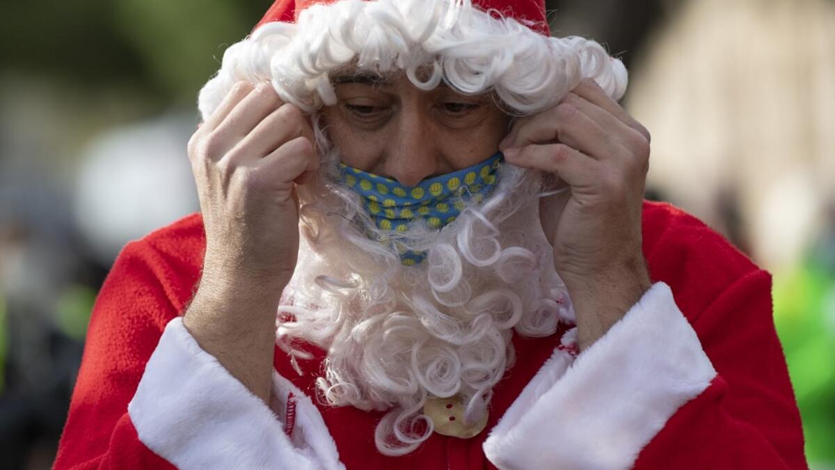 A swimmer in a Santa Claus costume prepares to participate in the 111th edition of the Copa Nadal (Christmas Cup) swimming race in Barcelona's Port Vell on December 25, 2020. The traditional 200-meter Christmas swimming race gathered around 300 participants on Barcelona's Port Vell (old harbour). Josep LAGO / AFP