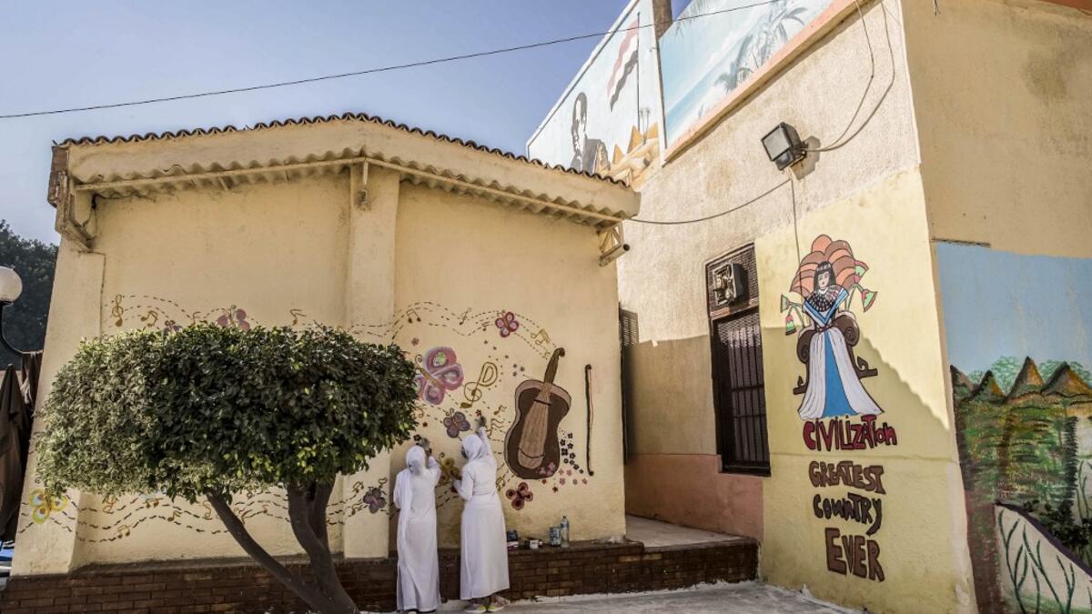 This picture taken during a government-guided tour on December 27, 2020 shows inmates drawing a mural on a wall at al-Qanatir women's prison, at the tip of the Nile delta in Qalyoubiya province, about 30 kilometres north of Egypt's capital. Khaled DESOUKI / AFP