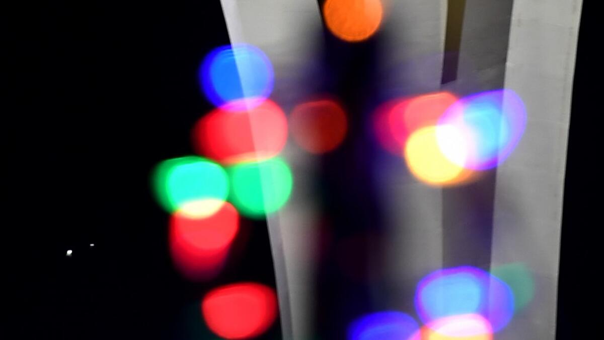 Jupiter (L) and Saturn appear about one-tenth of a degree apart during an astronomical event known as a Great Conjunction behind Christmas lights in the front yard of a house on December 21, 2020 in Las Vegas, Nevada. Ethan Miller / GETTY IMAGES NORTH AMERICA / Getty Images via AFP