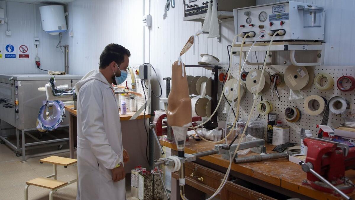 A member of staff works at the National Center for Artificial Limbs, in Libya's port city of Misrata, on December 17, 2020. With Libya's health sector left in tatters by its multiple conflicts since the 2011 revolution, war-wounded Libyans are often sent abroad for treatment, at the expense of the state. However, A national centre for prostheses, being established in Misrata, already has a patient waiting list of more than 3,000 amputees