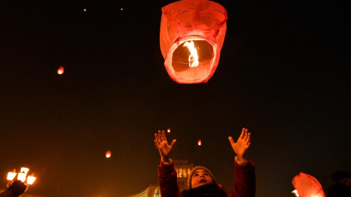 A girl launches a Chinese lantern during New Year celebrations in Yerevan early on January 1, 2021. Karen MINASYAN / AFP