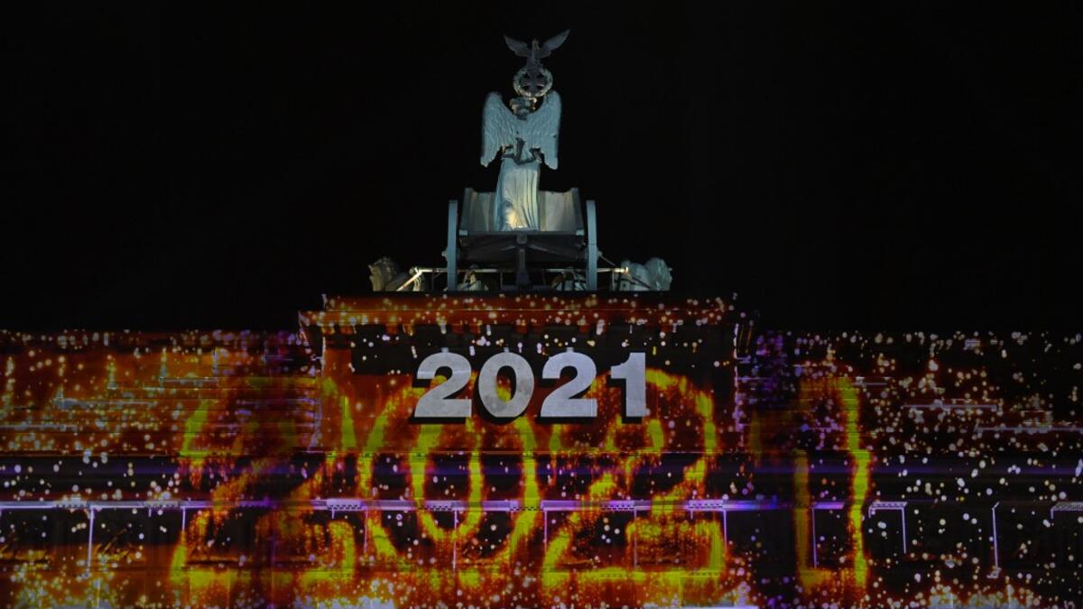 Berlin's landmark Brandenburg Gate is illuminated with the lettering '2021' at the start of a concert 'Willkommen 2021' (Welcome 2021) on New Year's Eve, December 31, 2020. This year's show at the Brandenburg Gate will take place without the traditional fireworks due to restrictions that apply during the current lockdown to curb the spread of the coronavirus (Covid-19) pandemic. John MACDOUGALL / AFP / POOL